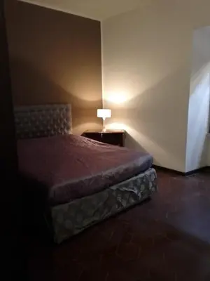a bedroom with a bed and a table with a lamp at Hostapartment SUITE UP in Rome