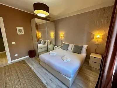 a bedroom with a large white bed and a mirror at Provincie 55 in Rome