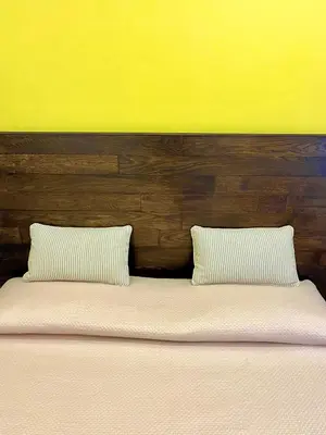 a bed with two white pillows and a wooden headboard at Interno Sette in Rome