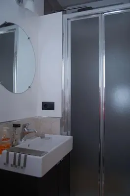 a bathroom with a sink and a shower with a mirror at Interno Sette in Rome
