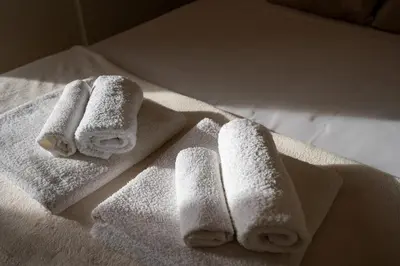 three towels sitting on a table in a bathroom at Elegante Appartamento presso Vaticano in Rome