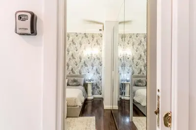 a hallway with a room with two beds and a mirror at Villa Borghese Gallery Rooms in Rome
