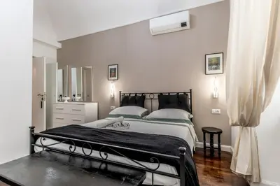 a white bedroom with a bed and a mirror at Villa Borghese Gallery Rooms in Rome