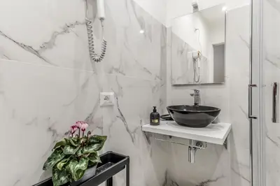 a white bathroom with a sink and a mirror at Villa Borghese Gallery Rooms in Rome