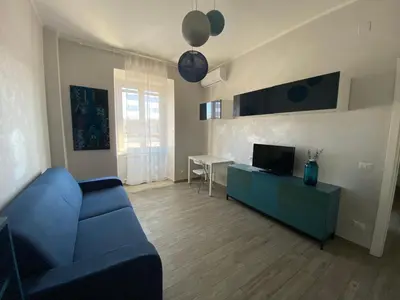 a living room with a blue couch and a television at Lola's house in Rome