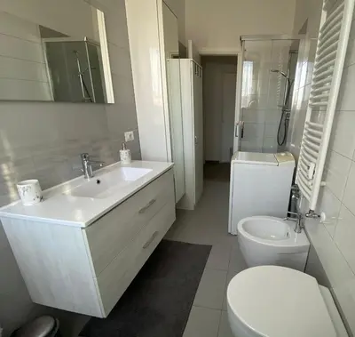 a white bathroom with a sink and a toilet at Lola's house in Rome
