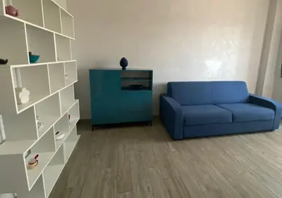 a living room with a blue couch and a cabinet at Lola's house in Rome