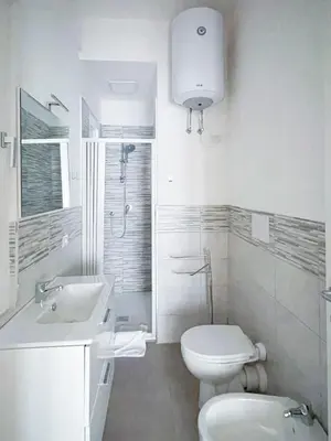 a white bathroom with a toilet and a sink at The Twenty - Vatican Apartment in Rome