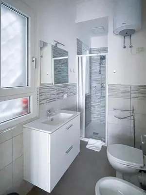 a white bathroom with a sink and a toilet at The Twenty - Vatican Apartment in Rome