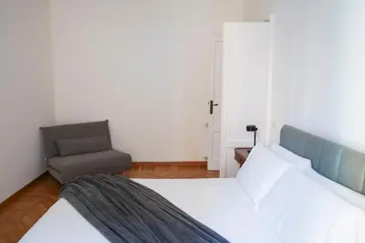 a bedroom with a bed and a chair at The Twenty - Mazzini apartment in Rome