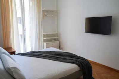 a bedroom with a bed and a flat screen tv at The Twenty - Mazzini apartment in Rome