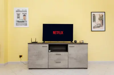 a flat screen tv sitting on top of a entertainment center at Your Whole Suite in Rome