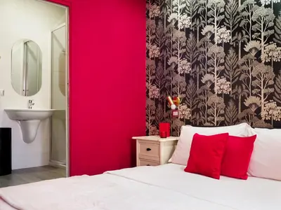 a red bedroom with a white bed and a red wall at C'est La Vie Suites in Rome
