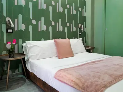 a bedroom with a bed with a green wall at C'est La Vie Suites in Rome