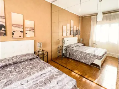 a bedroom with two beds and a glass wall at Casa di Eli in Rome