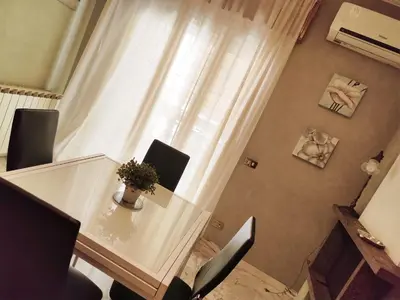 a table with a vase of flowers on it next to a window at Casa di Eli in Rome