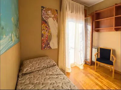 a bedroom with a bed and a window and a chair at Casa di Eli in Rome