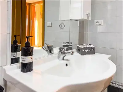 a bathroom with a white sink and a mirror at Casa di Eli in Rome