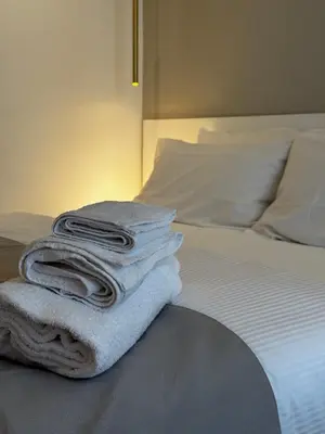 a stack of towels sitting on top of a bed at Ponte Milvio Suite & Parking- La Chambre de Sophie in Rome