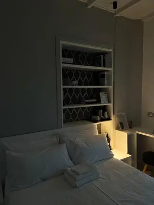 a bedroom with a bed and a shelf with wine bottles at Ponte Milvio Suite & Parking- La Chambre de Sophie in Rome