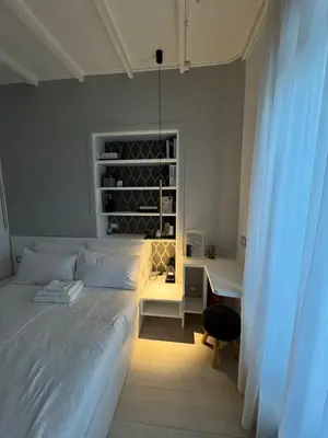 a bedroom with a white bed with a desk and a window at Ponte Milvio Suite & Parking- La Chambre de Sophie in Rome