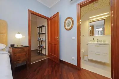 a bedroom with a bathroom with a sink and a mirror at La Petite Urbana Apartment in Rome