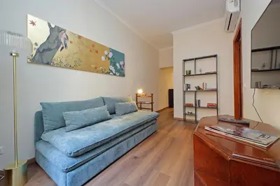 a living room with a blue couch and a table at La Petite Urbana Apartment in Rome