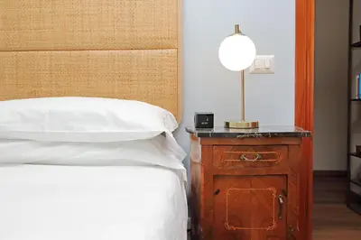 a bedroom with a bed and a wooden night stand at La Petite Urbana Apartment in Rome