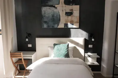 a bedroom with a white bed and a black wall at Numi B&B in Rome