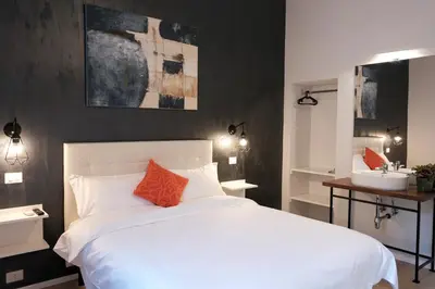 a bedroom with a white bed and a sink at Numi B&B in Rome