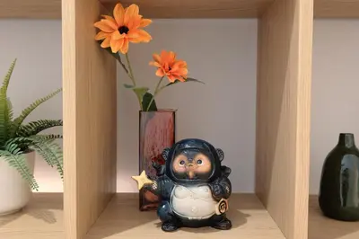 a figurine sitting on a shelf next to a vase with flowers at Numi B&B in Rome