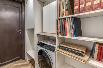 a laundry room with a washing machine and books at BelleArtiHome2 in Rome