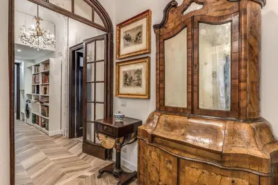 a large wooden cabinet in a hallway with a table at BelleArtiHome2 in Rome