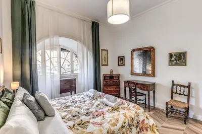 a bedroom with a bed and a table and a window at BelleArtiHome2 in Rome