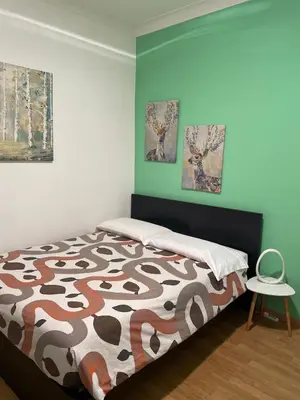 a bedroom with a bed and two paintings on the wall at Casa intera vicino il centro per 4 persone in Rome
