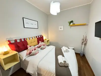 a bedroom with a bed with red and yellow pillows at Botticelli 2 Guesthouse in Rome