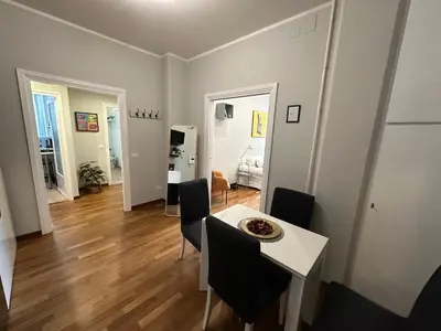 a living room with a table and chairs and a kitchen at Botticelli 2 Guesthouse in Rome