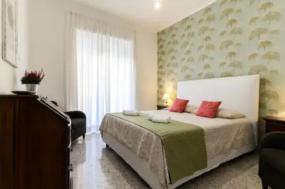 a bedroom with a large bed with red pillows at Casa Ausilia in Rome