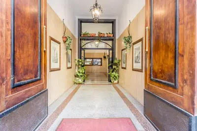a hallway with doors and plants on the walls at Sapienza Apt - Modern House in Piazza Bologna in Rome