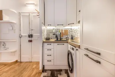 a kitchen with white cabinets and a washer and dryer at Sapienza Apt - Modern House in Piazza Bologna in Rome