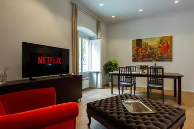 a living room with a tv and a red couch at Castroni Ottaviano Suite in Rome
