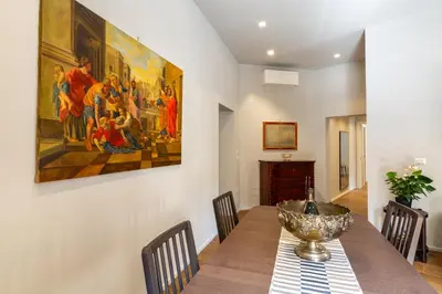 a dining room with a table and a painting on the wall at Castroni Ottaviano Suite in Rome