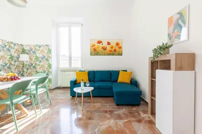 a living room with a blue couch and a table at Hostly-Maison Sant'Angelo-Few steps from Vatican in Rome
