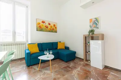 a living room with a blue couch and a table at Hostly-Maison Sant'Angelo-Few steps from Vatican in Rome