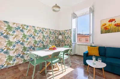 a living room with a table and chairs and a blue couch at Hostly-Maison Sant'Angelo-Few steps from Vatican in Rome