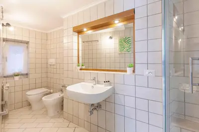 a bathroom with a sink and a toilet and a mirror at Hostly-Maison Sant'Angelo-Few steps from Vatican in Rome