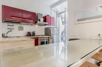a kitchen with red cabinets and a glass counter top at CasaTrastevere Alessio&Simone in Rome
