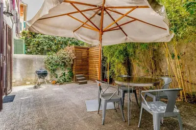 a patio with a table and chairs and an umbrella at CasaTrastevere Alessio&Simone in Rome