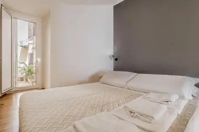 a white bed in a room with a window at CasaTrastevere Alessio&Simone in Rome