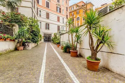 an empty street with palm trees and buildings at CasaTrastevere Alessio&Simone in Rome